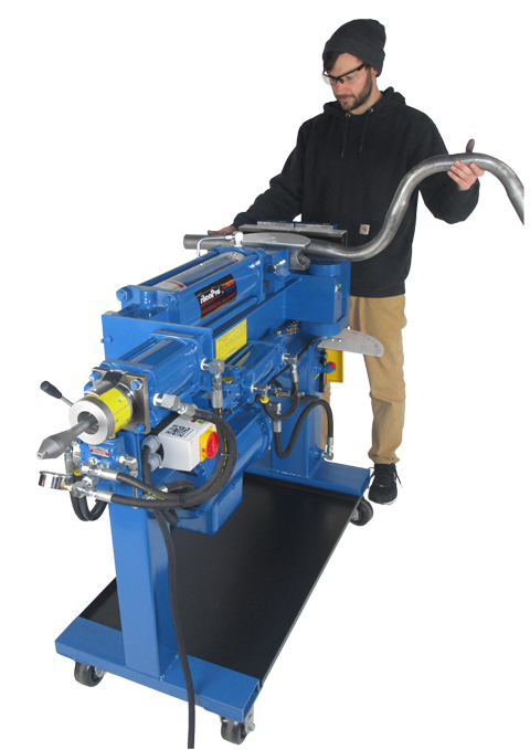 A man operates the Ben Pearson Model BP-04 bender, which is a large waist-high blue steel machine used for conveniently bending tube and pipe.