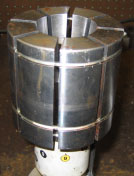 A cylindrical metal part is divided into 8 pie-shaped wedges; the part is for a Huth machine.