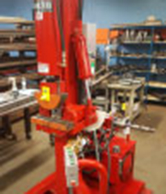 A bright orange vertical heavy-duty bender machine from Huth is shown in a shop.