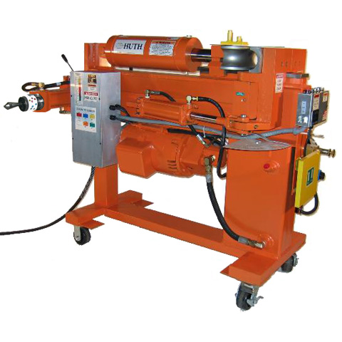 An orange Huth 2600 heavy-duty pipe bender is mounted on wheels and features a grey power box with black cords.