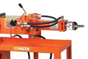 The Model 1673 expander is a large orange machine with black cords and metal end tooling.