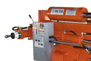 A Huth Heavy Duty Model 2600 machine bends even the strongest pipes and tubes with ease. The machine is orange with silver and black colored steel control features and tooling.