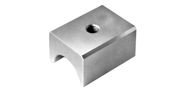 A square pipe-bending three-quarter shoe is made of steel and features a threaded hole in the center. The shoe has a half-moon-shaped cutout running across the bottom.